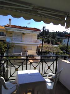 a balcony with a table and chairs and a building at Chrusanthi's Apartment in Nea Skioni