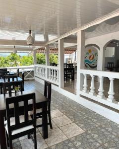 un restaurante con mesas y sillas en una habitación en Los Delfines Hotel & Dive Center en Little Corn Island