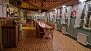 ein Restaurant mit einem langen Holztisch und Stühlen in der Unterkunft Skutskepparn Kuststation in Nordingrå