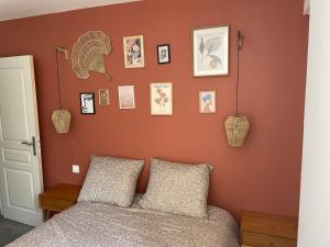 um quarto com paredes cor-de-laranja e uma cama com 2 almofadas em Appartement avec jardin privatif em Ajaccio