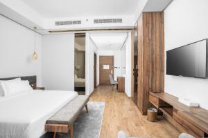 a bedroom with a bed and a flat screen tv at AKASIYA HOTEL in Doha