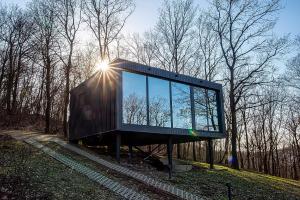 a glass building with the sun shining on it at ForRest Boutique Cabin in Dunabogdány