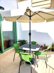 uma mesa e cadeiras com um guarda-sol num pátio em Sea View - Ultra Modern - Roof Terrace- Front Line em Mojácar