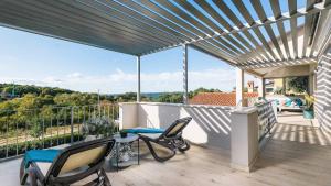 Un patio con sillas y una mesa en un balcón. en A stunning villa with a swimming pool in Lindar near Pazin, en Lindar