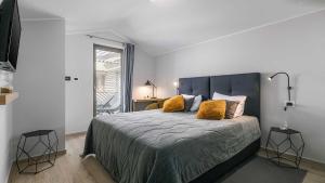 Un dormitorio con una cama grande con almohadas amarillas. en A stunning villa with a swimming pool in Lindar near Pazin, en Lindar 22 fotos más