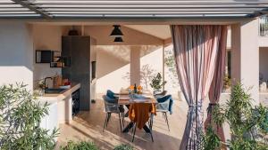 eine Terrasse mit einem Tisch und Stühlen sowie eine Küche in der Unterkunft A stunning villa with a swimming pool in Lindar near Pazin in Lindar