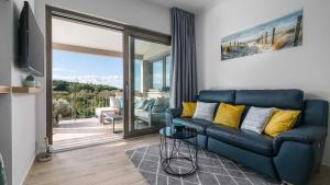 ein Wohnzimmer mit einem blauen Sofa und einem Balkon in der Unterkunft A stunning villa with a swimming pool in Lindar near Pazin in Lindar