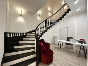 eine schwarze Treppe in einem weißen Zimmer mit einem Schreibtisch in der Unterkunft RIS Opera Apartments Yerevan in Yerevan