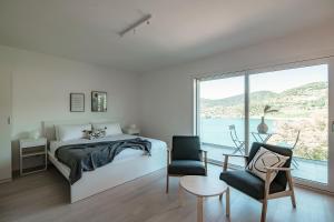 Schlafzimmer mit einem Bett, einem Tisch und Stühlen in der Unterkunft La Palma 1 by Quokka 360 - modern panoramic lake view flat in Montagnola