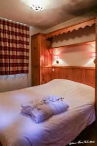 a bedroom with a white bed with flowers on it at travelski home premium - Résidence Les Alpages de Val Cenis 4 in Les Champs
