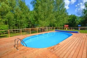 a large swimming pool on a wooden deck at Domki Spa Resort Bukowiec in Bukowiec +5 photos