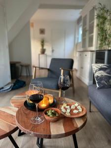 een tafel met twee glazen wijn en eten erop bij De Lijster in Bergen