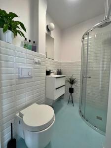 a white bathroom with a toilet and a shower at Szucha 27 - Royal Łazienki Flat in Warsaw
