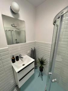 W białej łazience znajduje się umywalka i lustro. w obiekcie Szucha 27 - Royal Łazienki Flat w Warszawie