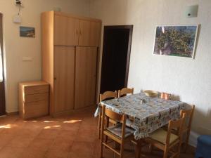 a dining room with a table and chairs and a cabinet at Seaside Cottage Bor in Gdinj +8 photos