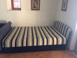 a bed with a striped mattress in a room at Seaside Cottage Bor in Gdinj