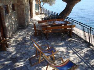 a table and chairs on a patio next to the water at Seaside Cottage Bor in Gdinj