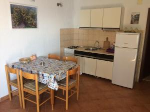 a kitchen with a table with chairs and a sink at Seaside Cottage Bor in Gdinj