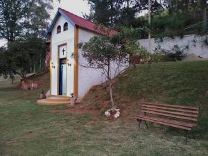 a small house with a bench in front of it at Fascinação Café Hotel in Cunha