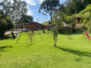 a playground with a tree and swings at Fascinação Café Hotel in Cunha