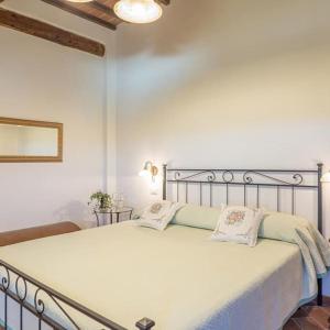 a bedroom with a large white bed with two pillows at Dimora del Grillo in Montepulciano