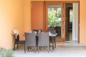 einen Tisch und Stühle auf einer Terrasse in der Unterkunft Villaggio Tamerici in Lignano Sabbiadoro