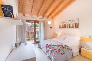 ein Schlafzimmer mit einem Bett und einem Balkon in der Unterkunft Villaggio Tamerici in Lignano Sabbiadoro