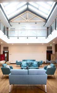 a living room with blue couches and a room with windows at Theodore House in Clitheroe