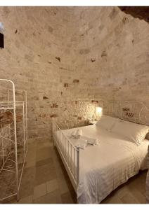 a bedroom with a white bed in a stone wall at i Trulli del Fauno in Alberobello +63 photos
