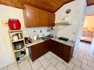 a small kitchen with wooden cabinets and a red appliance at Kikis Cottage in Antípaxos