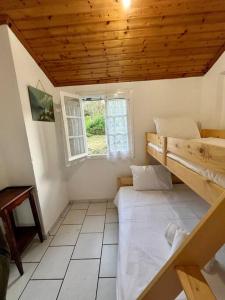 a bedroom with two bunk beds and a window at Kikis Cottage in Antípaxos
