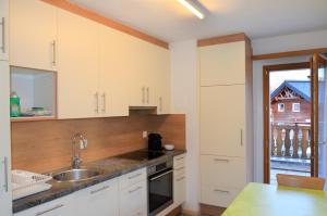 a kitchen with white cabinets and a sink at Chasa Arlu in Samnaun