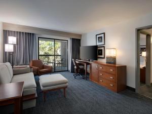 a hotel room with a desk and a living room at Courtyard Tampa North / I-75 Fletcher in Tampa