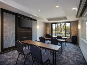 a conference room with tables and chairs and a flat screen tv at Courtyard Tampa North / I-75 Fletcher in Tampa