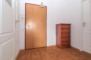 a wooden door in a room with a dresser at Horyzont Apartment in Gdańsk
