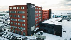 a red and black building with cars parked in a parking lot at Aurora Hotel at Reykjavik-Keflavik Airport Terminal KEF in Keflav&iacute;k