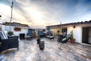 eine Terrasse mit Stühlen und Tischen auf einem Haus in der Unterkunft Cozy guest house Downtown in Olbia