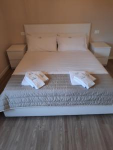 un grande letto bianco con due cuscini sopra di Il limone a Gargnano