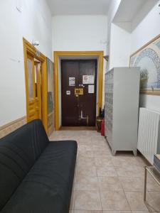 a living room with a couch in front of a door at SUNSHINE HOSTEL in Rome