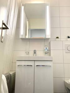 a white bathroom with a sink and a shower at Little Penthouse **** in Dietikon
