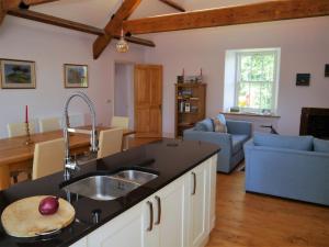 a kitchen with a sink and a living room at Rusko Stables in Gatehouse of Fleet