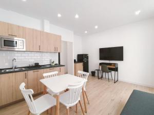una cucina e una sala da pranzo con tavolo e sedie di Apartamentos La Brava by gaiarooms a Salamanca
