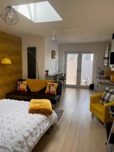sala de estar con cama y silla amarilla en Crow Nest, en Barton-on-Sea