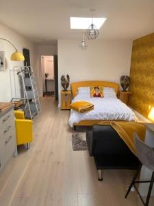 1 dormitorio con 1 cama con cabecero amarillo en Crow Nest, en Barton-on-Sea