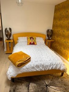 a bedroom with a bed with a yellow blanket at Crow Nest in Barton on Sea