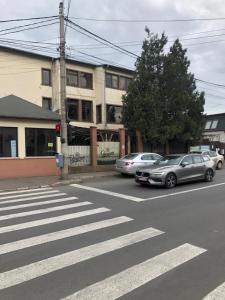 una calle con coches estacionados frente a un edificio en La o Barfa, en Ploieşti