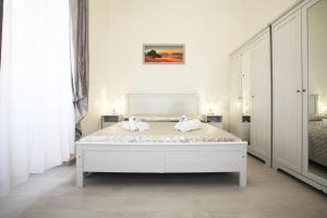 a white bedroom with a bed with towels on it at Brillante Appartamento di Sara -Daniele Case Vacanza in Anzio