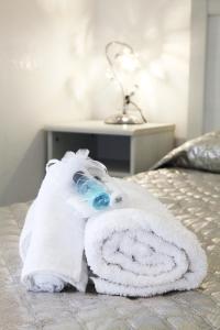 a towel on a bed with a bottle on it at Brillante Appartamento di Sara -Daniele Case Vacanza in Anzio