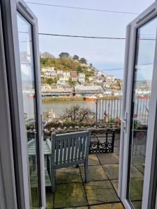 a balcony with a bench and a view of the water at Polmear Harbour View With Terrace in Looe
