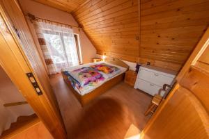 una piccola camera da letto con un letto in una camera in legno di Agroturystyka na szlaku a Lubomierz